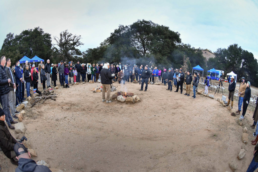 Image of a group of people surrounding a camp fire