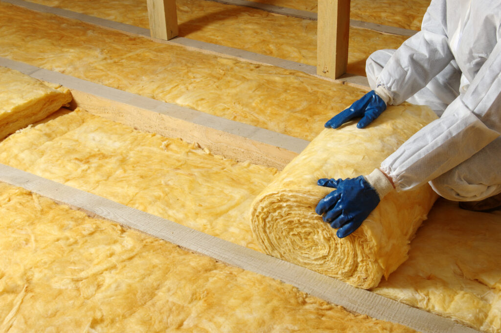 Worker installing attic insulation.