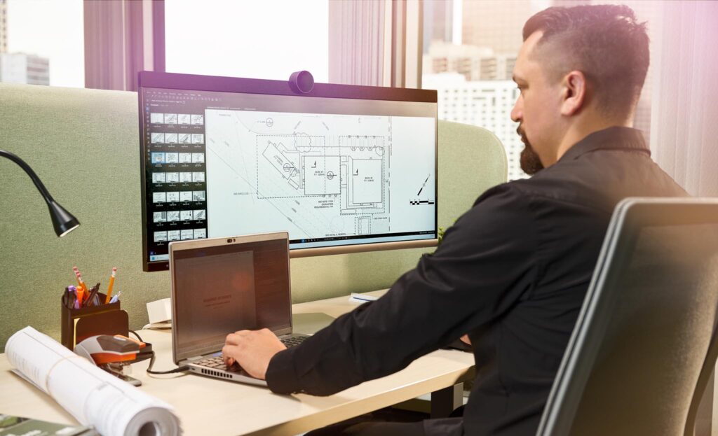 Man in front of a computer looking at plans